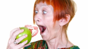Photoshopped photo of woman's surprise a bite of apple took her dentures right out of her mouth because they were too loose