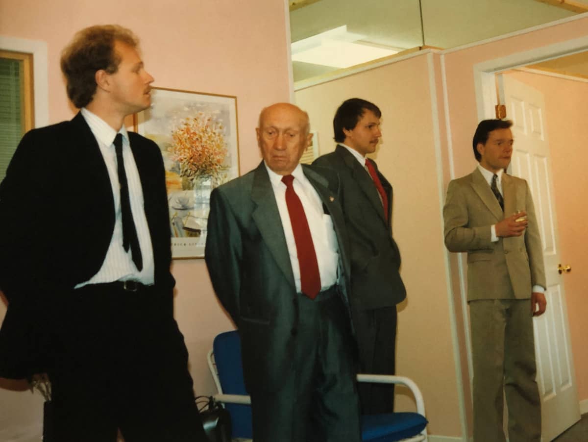 Tim standing with his partner, Mark, at the grand opening of their Oakville Denture Cinic, with grandfather Joe Sr. and brother Gary, all in suits
