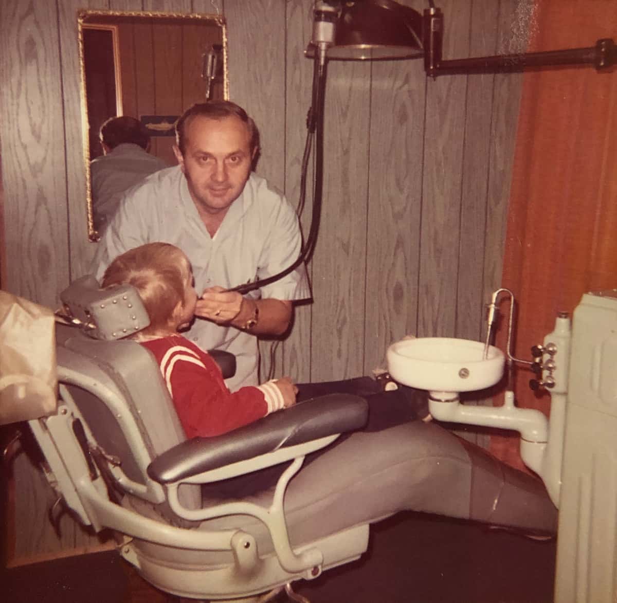 A young Joe Schankula pretending to work on 6 year old Tim in dental chair