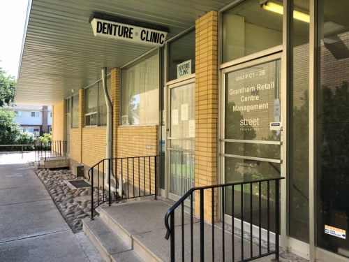 Entrance of the Grantham Denture Clinic showing a porch with 2 steps, railings on both sides, leading to two doors, one the clinic and the other the Grantham Retail Centre Management