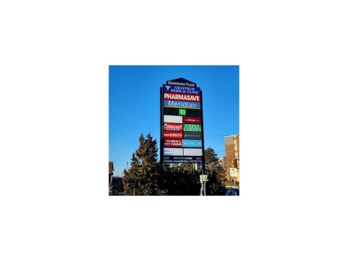 The Grantham Plaza sign at the Sobey's Supermarket end, with signage for Grantham Medical Clinic, Pharmasave, Meridian Bank, TD Bank, The Wine Shop, Osmows Restaurant, China Garden, Bar Burrito, Spirit Leaf Cannabis Store, Global Pet Foods, and the Kumon Math and Reading Centre