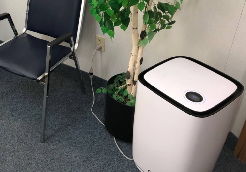 32-Closeup of the large floor air purifier, next to an artificial plant and chair